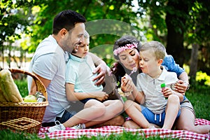 Family with children blow soap bubbles outdoors