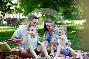 Family with children blow soap bubbles outdoors