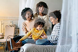 Family children gay parents concept. Happy multiethnic women couple having fun with kids at home