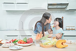 Family. Children and happy people concept. Asian mother and kid daughter cooking in the kitchen at home