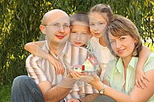 Family with children keeping wendy house in hands