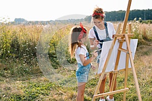 family, children and people concept - happy mother and daughter drawing and talking over green background. Mother& x27;s