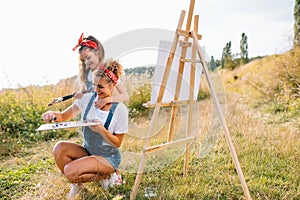 family, children and people concept - happy mother and daughter drawing and talking over green background. Mother& x27;s