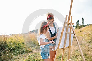 family, children and people concept - happy mother and daughter drawing and talking over green background. Mother& x27;s