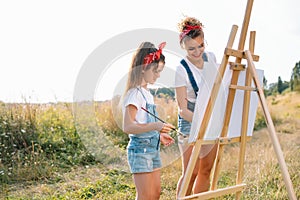 family, children and people concept - happy mother and daughter drawing and talking over green background. Mother& x27;s