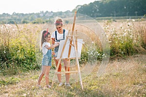 family, children and people concept - happy mother and daughter drawing and talking over green background. Mother& x27;s