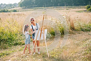 family, children and people concept - happy mother and daughter drawing and talking over green background. Mother& x27;s