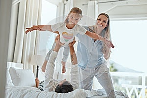 Family, children and playful with a girl, mother and father having fun together in the bedroom of their home. Kids