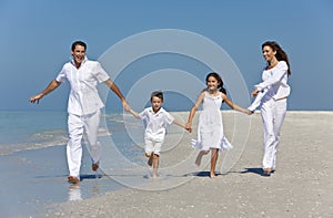Family With Children Running Having Fun At Beach