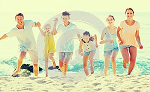 Family with children running together on beach