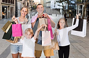 Family with children standing and holding shopping bags