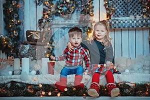 Family on Christmas background. Kids opening Xmas presents. Children under Christmas tree with gift boxes and candles. Decorated