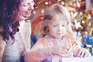 Family at Christmas day unwrapping presents under the tree