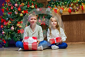 Family on Christmas eve at fireplace. Kids opening Xmas presents