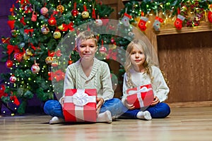 Family on Christmas eve at fireplace. Kids opening Xmas presents