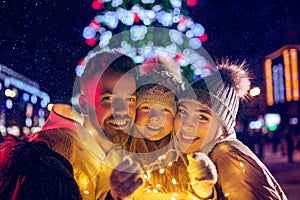 Family, christmas, holidays, season and people concept - happy family over city background and snow