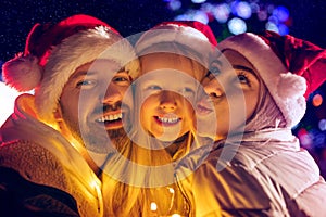 Family, christmas, holidays, season and people concept - happy family over city background and snow