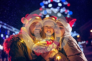 Family, christmas, holidays, season and people concept - happy family over city background and snow