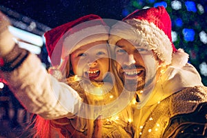 Family, christmas, holidays, season and people concept - happy family over city background and snow