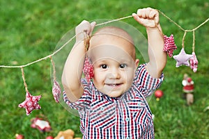 Family Christmas in July. Portrait of little boy near christmas tree. Baby decorating pine. Winter holidays and people concept.