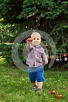 Family Christmas in July. Portrait of little boy near christmas tree. Baby decorating pine. Winter holidays and people concept.