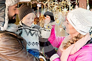 Family on Christmas market buying ornaments and baubles