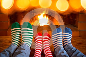 Family in Christmas socks near fireplace