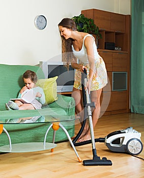 Family cleaning home with vacuum cleaner