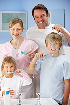 Family cleaning teeth together in bathroom