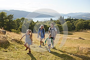 Family Climbing Hill On Hike Through Countryside In Lake District UK Together