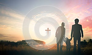 Family concept: Parents and children pray together on the cross background