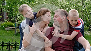 Family concept shot - woman and man with their children boys enjoy sunny day outdoors