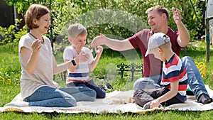 Family concept shot - woman and man and their children boys playing game enjoy sunny day outdoors