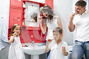 Family Concepts. Young Caucasian Family with The Kids Having Fun in Bathroom While Brushing Teeth Together photo