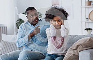 Family conflict caused by coronavirus isolation. Angry granddad and his granddaughter closing her ears indoors