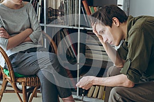 Family conflict. Couple discussing sitting near bookshelves