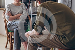 Family conflict. Couple discussing sitting near bookshelves