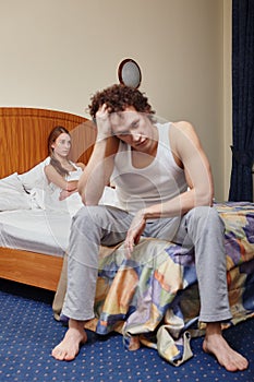 Family conflict. Young couple quarrels in bedroom at home.  Selective focus on woman