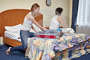 Family conflict. Young woman packing  things in suitcase is going to leave the husband. Divorce. Selective focus on woman