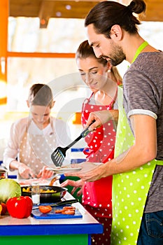 Family cooking healthy food in domestic kitchen