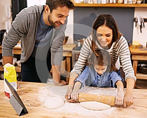 Family, cooking and learning in kitchen with tablet for recipe, guide and parents with child in home. Baking, mom and