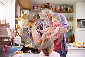 Family Cooking Meal In Kitchen Together