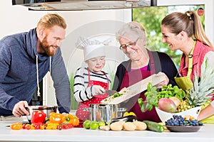 Family cooking in multigenerational household with son, mother,
