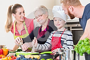 Family cooking in multigenerational household with son, mother, photo