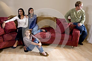 Family on couch with father sitting apart