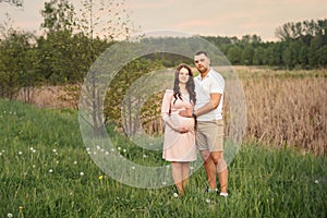 Family couple in the forest park Woman pregnant Future parents in anticipation of the baby