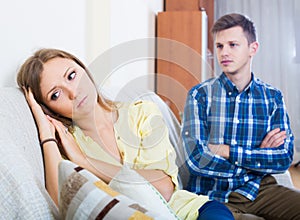 family couple with serious faces quarrelling at home