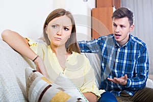 Family couple with serious faces quarrelling at home