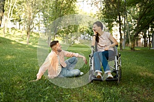 Family couple with wheelchair leisures in park