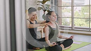 Family couple, woman doing yoga sitting meditating on lotus pose workout at home and the man massage shoulder